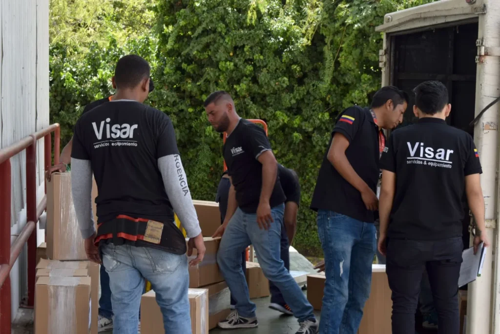 Equipo de VISAR descargando y revisando cajas en el muelle de la bodega
